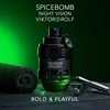A bottle of Viktor & Rolf Spicebomb Night Vision fragrance is displayed prominently, with a rolled-up towel and a metal object to its sides. The background is a gradient of dark green to black, and text overlays highlight the product name and a tagline. Produktbild-Vorschau