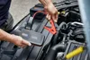 A person is using a jump starter to start a car. Náhled obrázku produktu