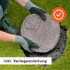 Hands wearing gloves placing a log-shaped stepping stone into a hole in a grassy lawn. A checkmark icon is in the upper right corner, and text is at the bottom. Anteprima dell’immagine prodotto