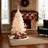 A white Christmas tree decorated with lights and ornaments, standing in a living room with a fireplace and gifts underneath. Náhľad obrázku produktu