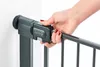 A hand is shown operating the locking mechanism of a safety gate. Voir les images du produit