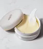 A jar of eye patches with a spatula, lid slightly ajar. Voir les images du produit