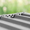 A close-up view of the top edge of a metal garden shed, showing the guttering and a perforated metal strip for ventilation. Anteprima dell’immagine prodotto