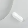 A close-up view of a white toilet seat with a white button mechanism. Anteprima dell’immagine prodotto