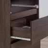 Close-up view of drawers and drawer slides of a dark wood dresser. Voir les images du produit