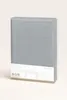 A folded grey jersey fitted sheet is presented upright against a light grey background. Produktbild-Vorschau