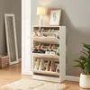 A white shoe cabinet with multiple compartments filled with shoes, placed in a hallway next to a mirror and a plant. Anteprima dell’immagine prodotto