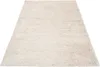 A beige shaggy rug is shown from a slightly elevated angle against a white background. Produktbild-Vorschau
