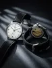 Two watches are displayed on a dark, textured surface with dramatic lighting casting shadows. Voir les images du produit