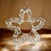 A decorative LED flower light sits on a wooden surface. Produktbild-Vorschau
