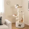 A cat tree with multiple levels and cats on it, placed in a living room setting next to a sofa. Anteprima dell’immagine prodotto