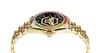 A close-up side view of a gold watch with a black face and a rainbow-colored bezel. Anteprima dell’immagine prodotto