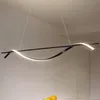 A modern LED pendant light fixture hangs from the ceiling, illuminating a space above a table with fruit. Produktbild-Vorschau