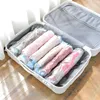 A suitcase is open and filled with rolled-up clothes in vacuum-sealed bags. Voir les images du produit