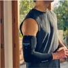 A man wearing a black compression sleeve on his arm. Podgląd zdjęcia produktu