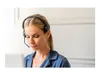 A woman wearing a headset, looking down. Voir les images du produit
