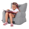 A young girl is sitting in a gray beanbag chair and reading a book. Náhľad obrázku produktu