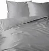 A close-up view of a grey duvet cover and pillowcases with white piping.