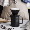 Pouring hot water from a kettle into a coffee filter set on a carafe. Produktbild-Vorschau