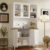 A white hutch cabinet with glass doors and wooden accents, filled with various decorative items and books. The cabinet is placed in a room setting with a lamp and artwork on the wall. Podgląd zdjęcia produktu