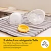 Three parts of a breast pump are laid out on a striped towel on a counter. Voir les images du produit
