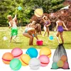 Children playing with water balls in a yard. Produktbild-Vorschau