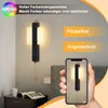 A modern black LED wall lamp with a frosted white shade, shown mounted on a wall next to a bed. A smartphone displays a similar lamp, and text highlights product features. Anteprima dell’immagine prodotto