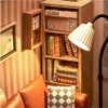 A miniature bookshelf with books, a clock, and a lamp, next to a sofa. Podgląd zdjęcia produktu