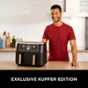 A man stands in a kitchen next to a black and copper air fryer. Produktbild-Vorschau