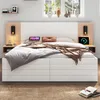 A modern bedroom with a white and wood tone bed, featuring integrated nightstands and charging capabilities. Produktbild-Vorschau