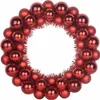 A wreath made of red Christmas ornaments and tinsel on a white background. Produktbild-Vorschau