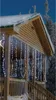 Icicle lights are decorating a wooden porch during a winter night. Voir les images du produit