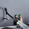 A flexible kitchen faucet spraying water into a sink, with two bottles of condiments in the background. Náhľad obrázku produktu