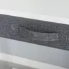 A close-up view of a gray fabric storage box with a handle. Anteprima dell’immagine prodotto