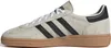 A side view of a beige Adidas sneaker with black stripes and a brown sole. Voir les images du produit