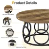 A round coffee table with a wood-grain top and a black metal base with circular accents, with callouts highlighting its features. Podgląd zdjęcia produktu