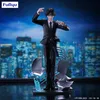 A statue of a character in a suit standing in front of a city skyline at night. Produktbild-Vorschau