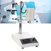 A laboratory homogenizer with a microscope and other lab equipment in the background. Náhľad obrázku produktu
