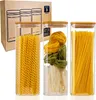 Three glass food storage containers filled with different types of pasta, placed in front of their cardboard packaging. Produktbild-Vorschau