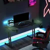 A gaming desk setup with a computer, keyboard, mouse, and gaming chair, illuminated by LED lights. Produktbild-Vorschau