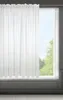 A white sheer curtain hangs in front of a window, with trees and sky visible outside. Produktbild-Vorschau