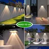 Collage of four images showing solar wall lights installed in different outdoor settings. Produktbild-Vorschau