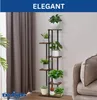 A multi-tiered plant stand with several potted plants is shown next to a sofa and curtains. Produktbild-Vorschau