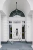 A silver ladder is placed in front of a white door on a gray porch. Anteprima dell’immagine prodotto