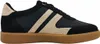 A side view of a black sneaker with beige accents and a brown sole. Voir les images du produit