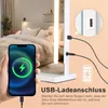 A hand holding a smartphone is in the foreground, showing a charging battery icon. Behind it, a lighted vanity mirror is shown with cables connected, and a bedroom with a bed is visible in the background. Podgląd zdjęcia produktu