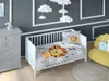 A nursery room with a crib, dresser, and chair, decorated with cloud-themed mobile. Produktbild-Vorschau