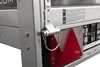 Close-up of a trailer's rear corner, showing a red reflector and a metal hinge mechanism. Podgląd zdjęcia produktu