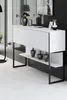A modern white console table with black metal legs, decorated with vases and a framed picture on top, set against a striped black and white wall. Anteprima dell’immagine prodotto