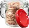 Three small glass jars, one filled with pinkish crystals, and a red lid are arranged on a white background. Podgląd zdjęcia produktu